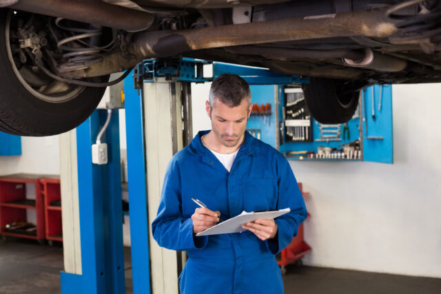 Mechanic writing on a clipboard